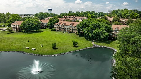 A fountain in the middle of a lake surrounded by houses