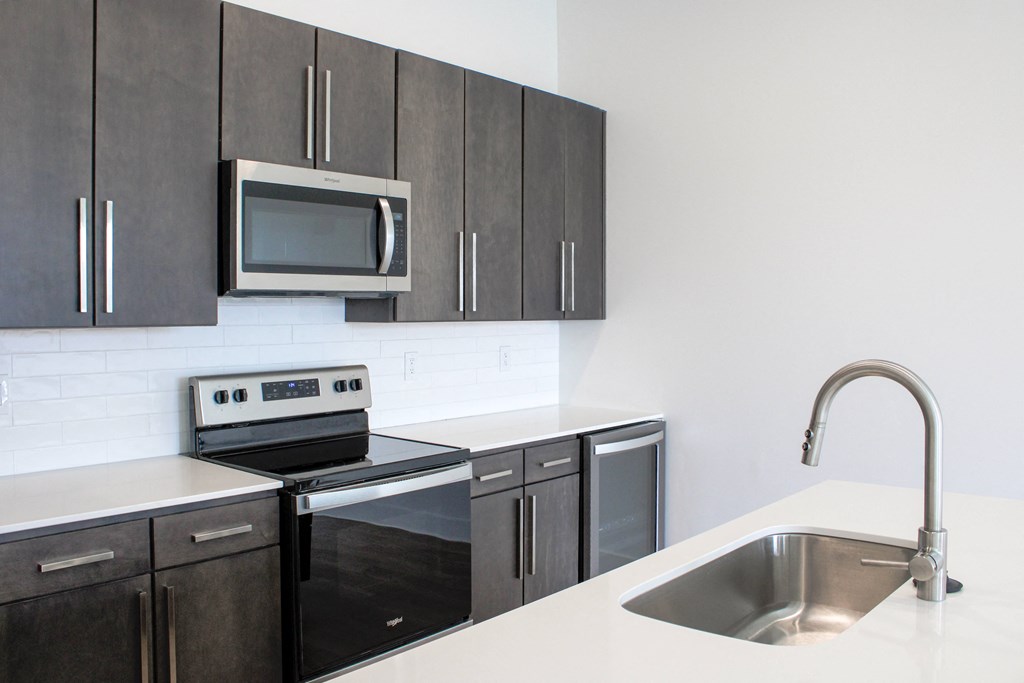 a kitchen with dark cabinets and white countertops  at Avant & Avant II, Carmel, IN