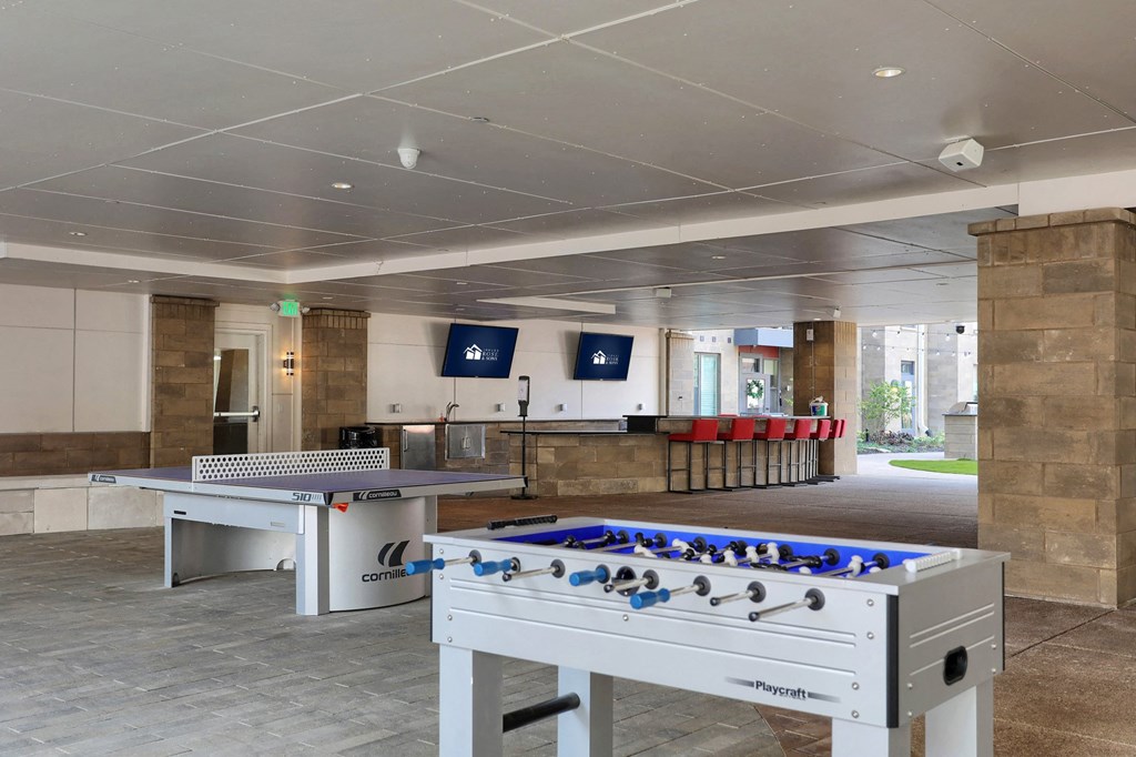 outdoor grotto with two foosball tables and a ping pong table in Carmel, IN