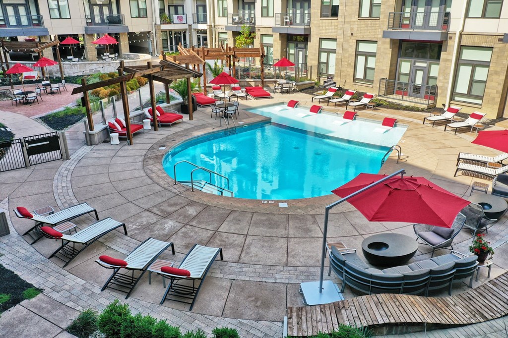 a swimming pool in the middle of a courtyard with chairs and umbrellas in Carmel, 46032