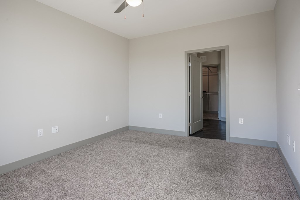 an empty living room with carpeting and a door to a hallway at Avant & Avant II, Carmel, IN, 46032