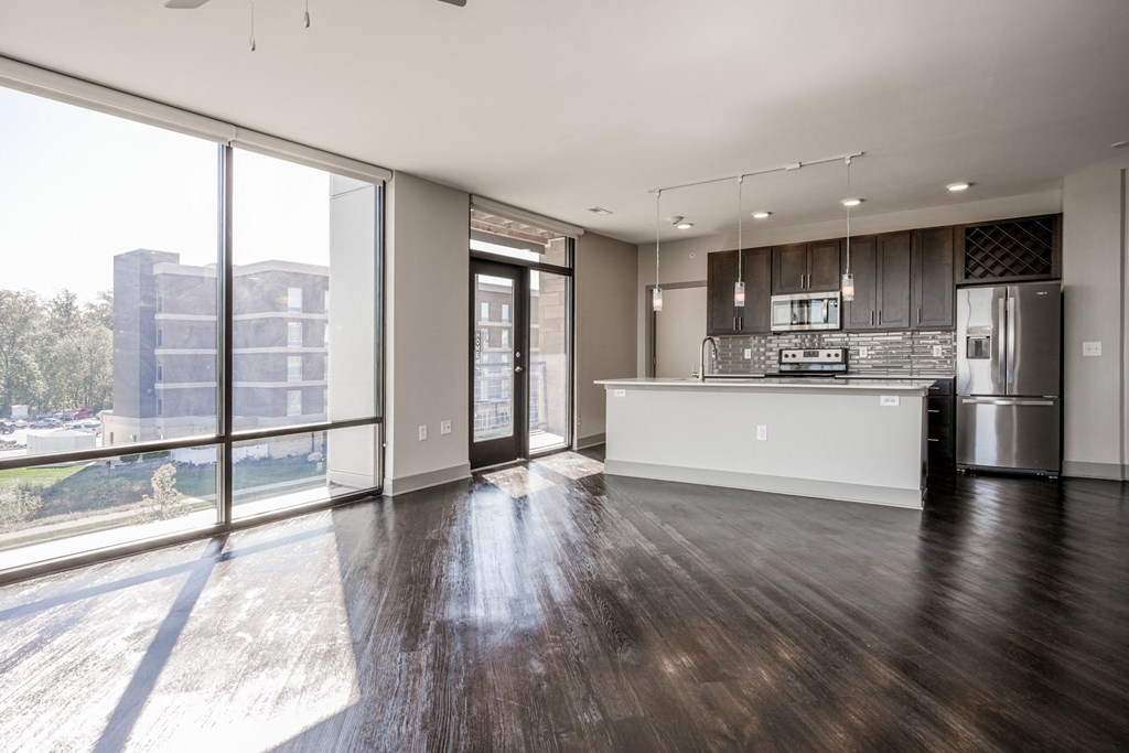 an empty living room with a kitchen and a large window at Avant & Avant II, Carmel, IN, 46032