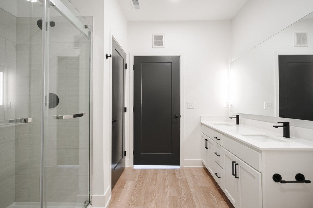 a bathroom with a sink and a shower and a black door at Avant & Avant II, Carmel, IN, 46032