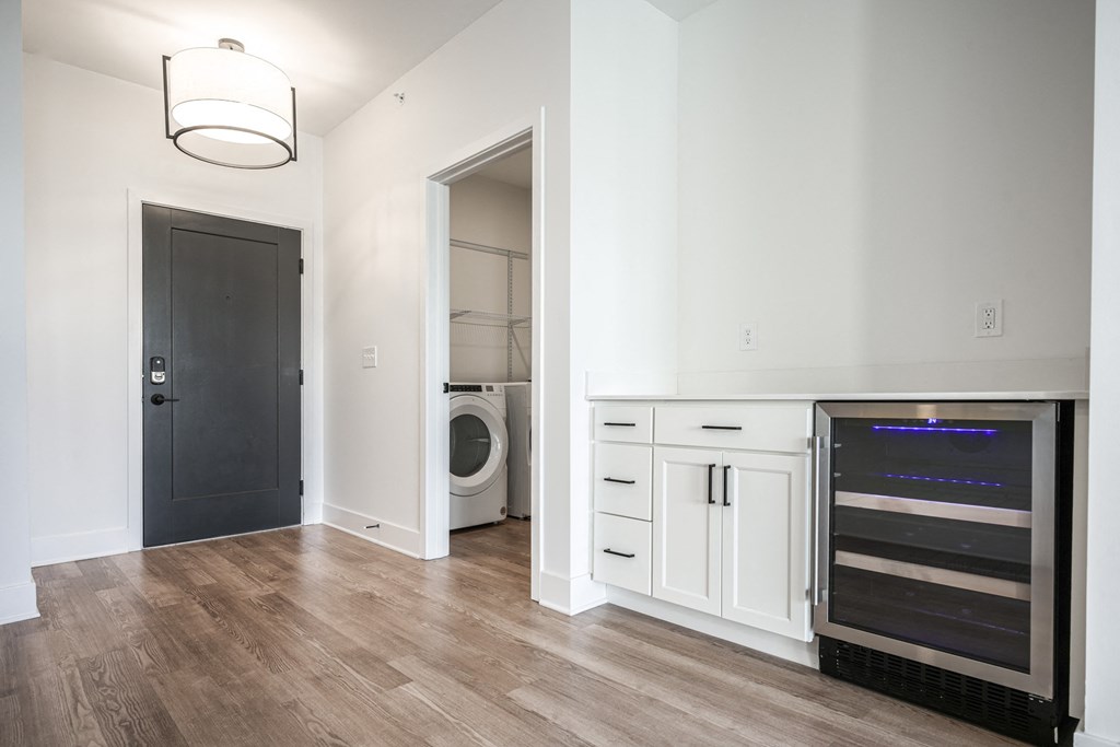 a living room with a washer and dryer and a door to a bathroom at Avant & Avant II, Carmel, IN, 46032