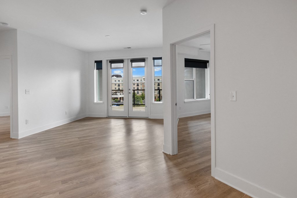 a living room with white walls and a door to a balcony in Carmel, IN