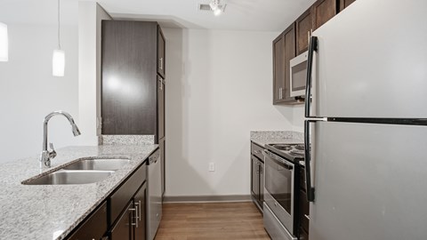A kitchen with a sink and a refrigerator.
