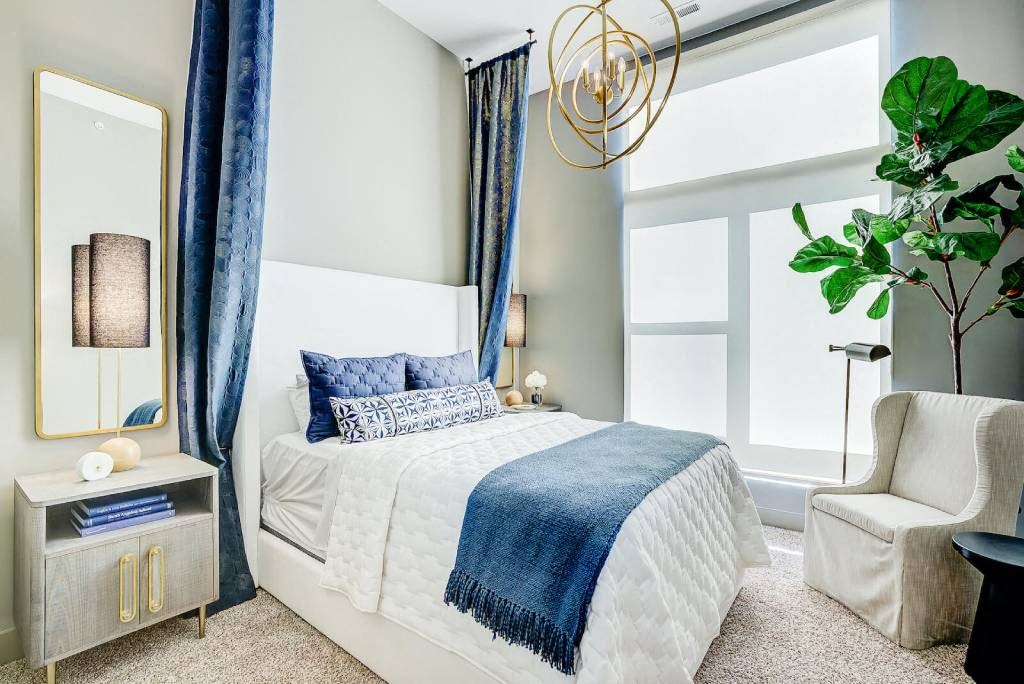 a bedroom with a bed and a chair in front of a window  at Avant & Avant II, Carmel, Indiana