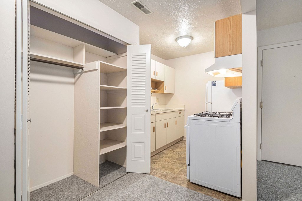a renovated kitchen with white appliances and white shelves at Briarwood Apartments, Benton Harbor, Michigan