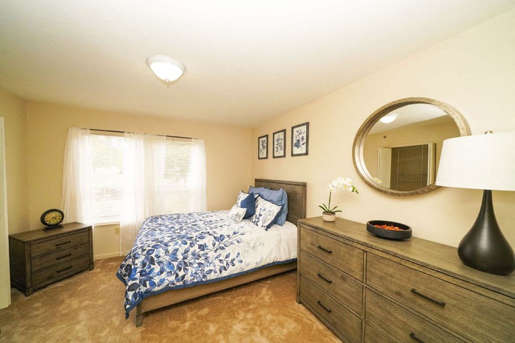 a spacious bedroom with a bed and a mirror at Black Sand Apartment Homes, Lincoln, NE