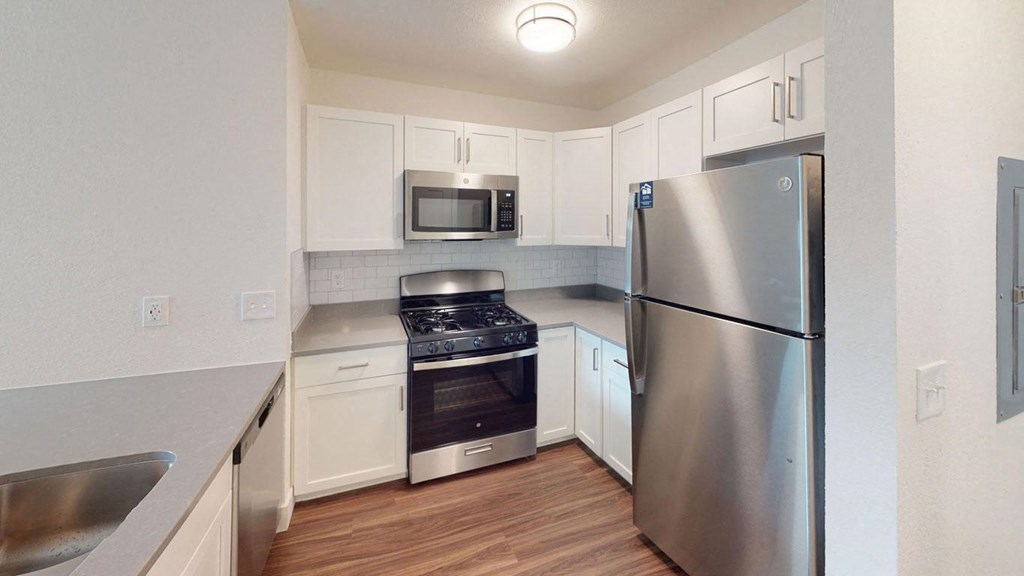 a two bedroom kitchen with stainless steel appliances and white cabinets  at Byron Lakes Apartments, Michigan, 49315