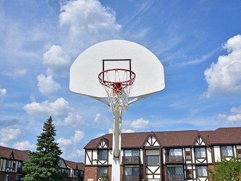 Outdoor basketball court with residential buildings at Charter Oaks Apartments, Davison, MI