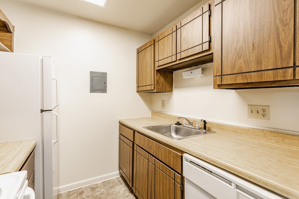 A kitchen with wooden cabinets and a white refrigerator