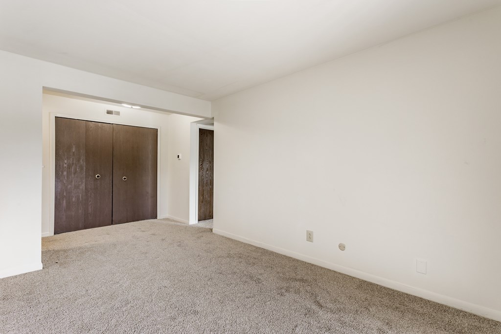 A room with a carpeted floor and a brown door