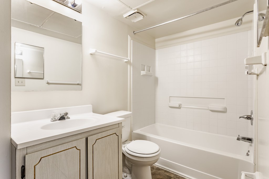 A white bathroom with a toilet, sink, and bathtub