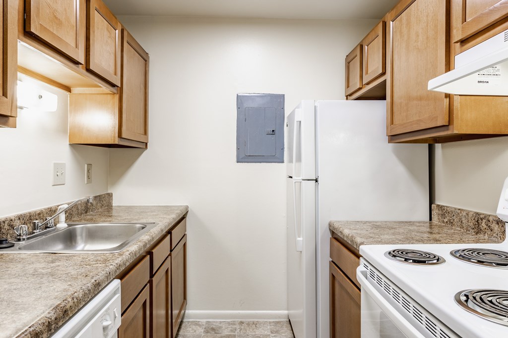 A kitchen with a white refrigerator and a stove top oven