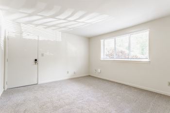 A room with a white door and a window with blinds