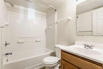 A white bathroom with a toilet, sink, and bathtub