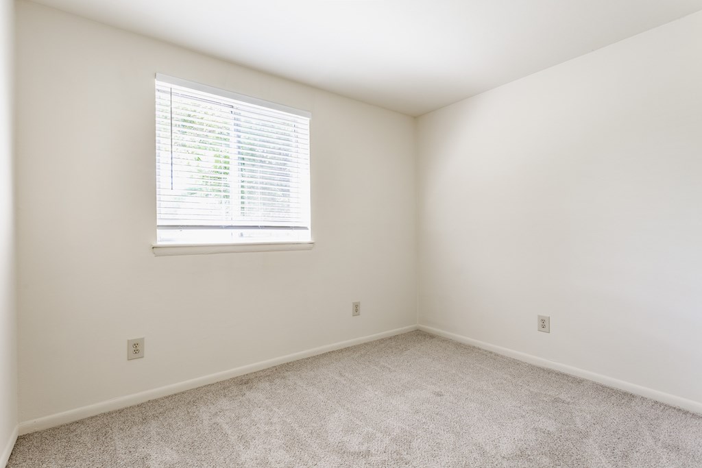 A room with a window and carpeted floor