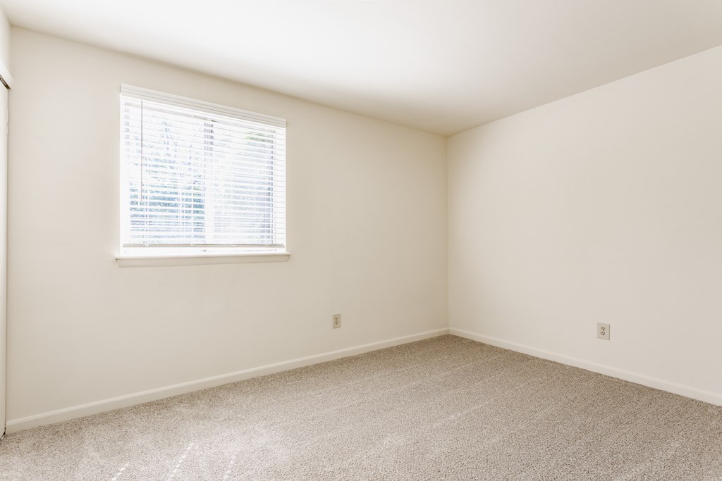A room with a window and carpeted floor
