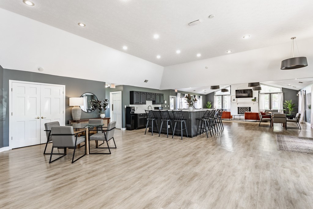 A modern open-plan living and dining area with a kitchen in the background