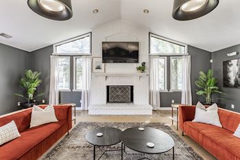 A living room with a fireplace and a television mounted above it