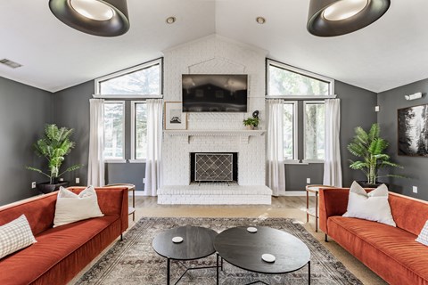 A living room with a fireplace and a television mounted above it.