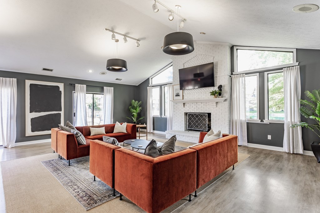 A modern living room with a red couch and a fireplace