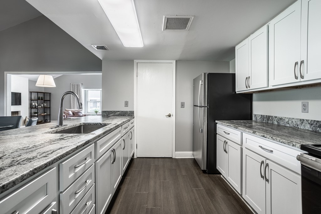 A modern kitchen with white cabinets and a black refrigerator