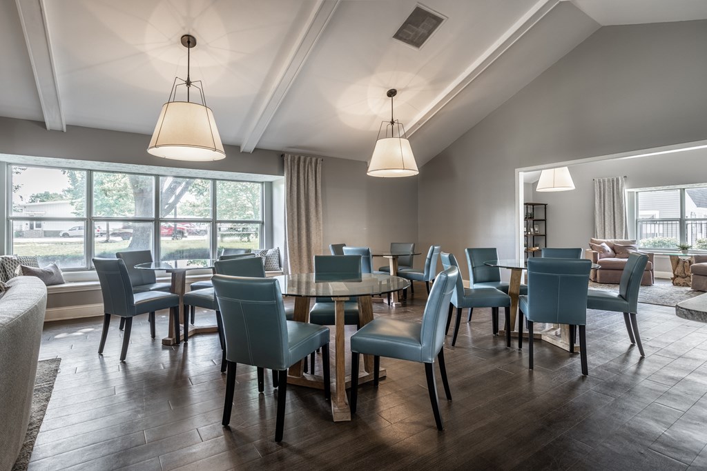 A room with a table and chairs with a window in the background