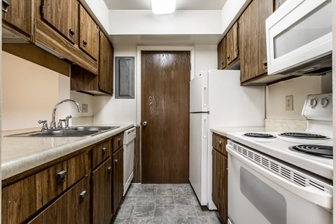 a kitchen with white appliances and wooden cabinets
