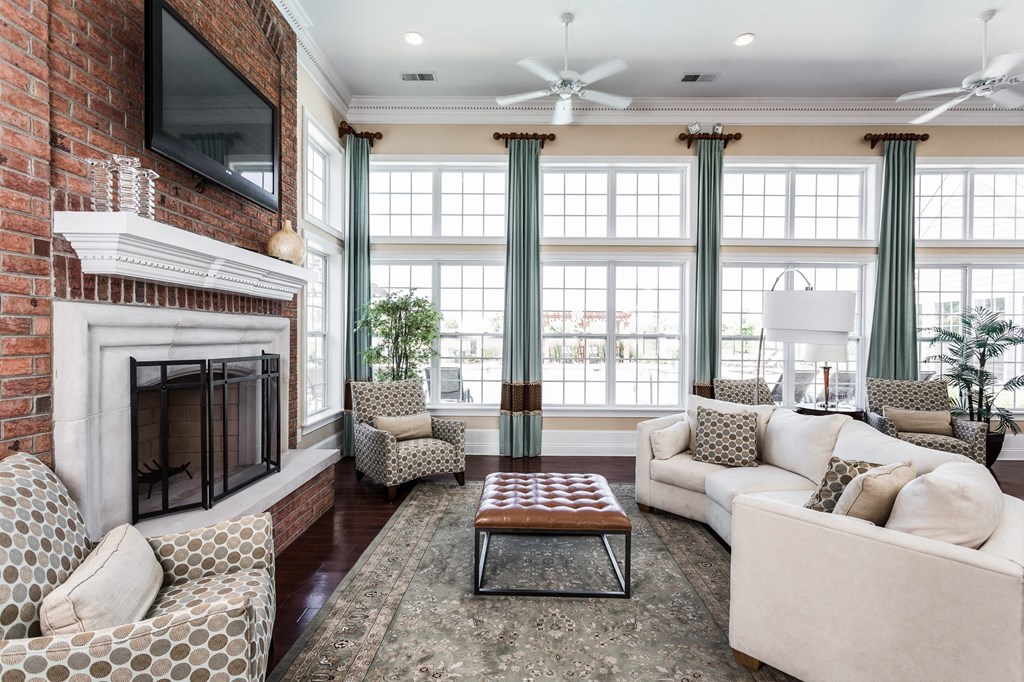a living room with a brick fireplace and a couch and a coffee table at Brickshire Apartments, Merrillville, Indiana