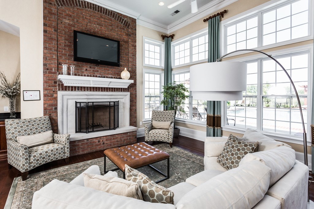 a living room with a white couch and a brick fireplace at Brickshire Apartments, Merrillville