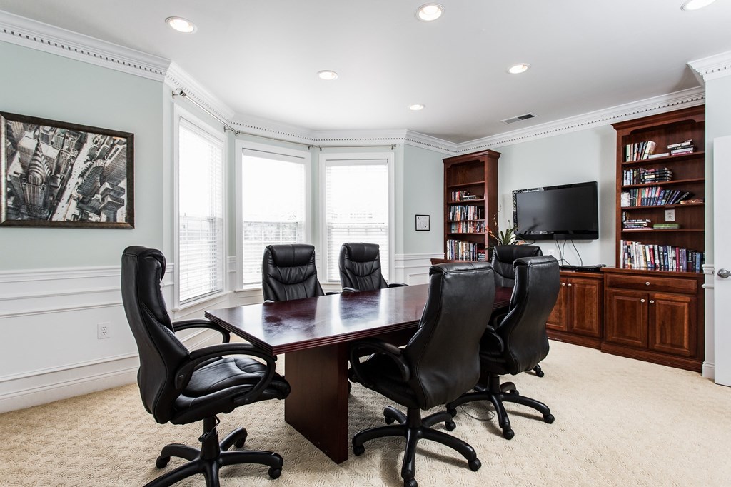 a conference room with a table and chairs and a television at Brickshire Apartments, Merrillville, IN, 46410