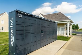 A large Amazon hub container is parked in front of a house