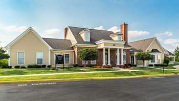 A large house with a brick chimney is situated on a street corner