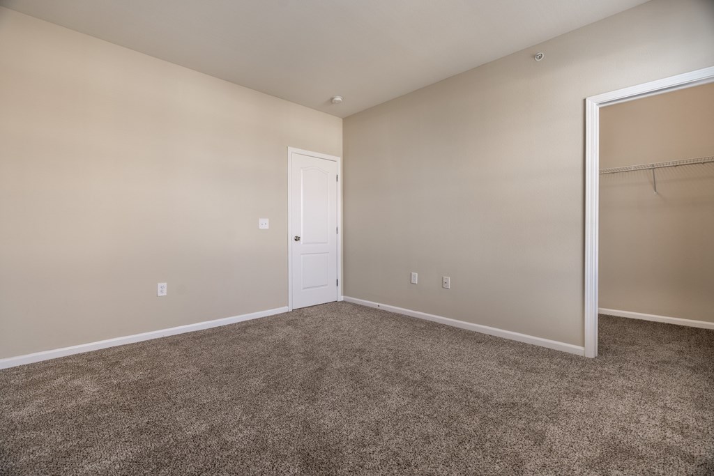 A room with a carpeted floor and a white door