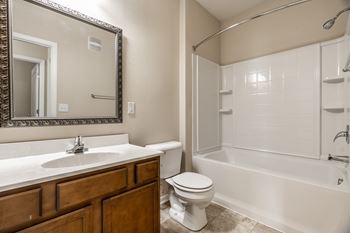 A white bathroom with a toilet, sink, and bathtub