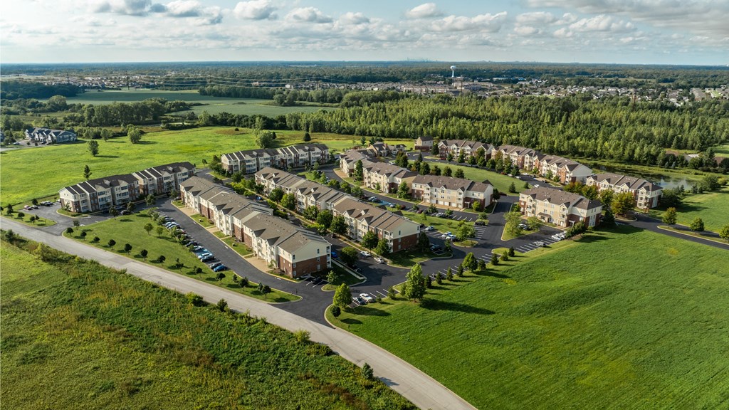 A large housing complex with a green lawn in front