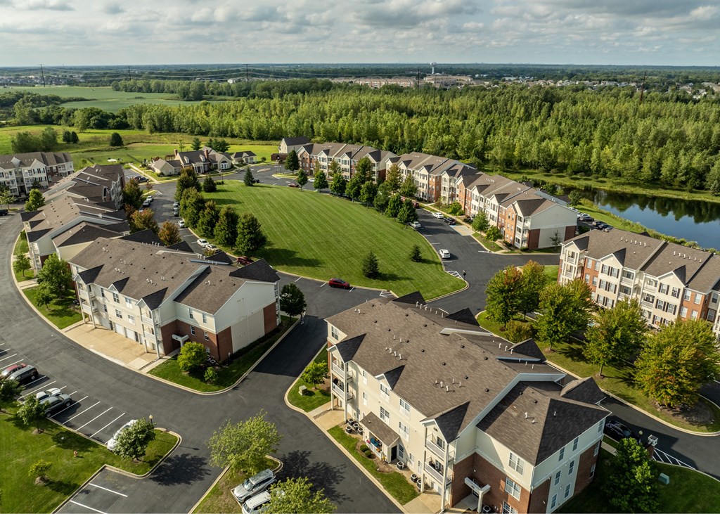 A bird's eye view of a residential complex with a lake in the background