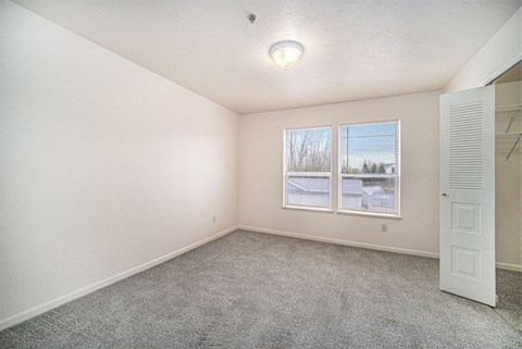 bedroom with a large window and walk-in closet  at Canal 2 Apartments, Lansing, 48917