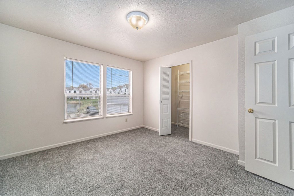 Bedroom with Large Closet and Multiple Windows at Canal 2 Apartments in Lansing, MI
