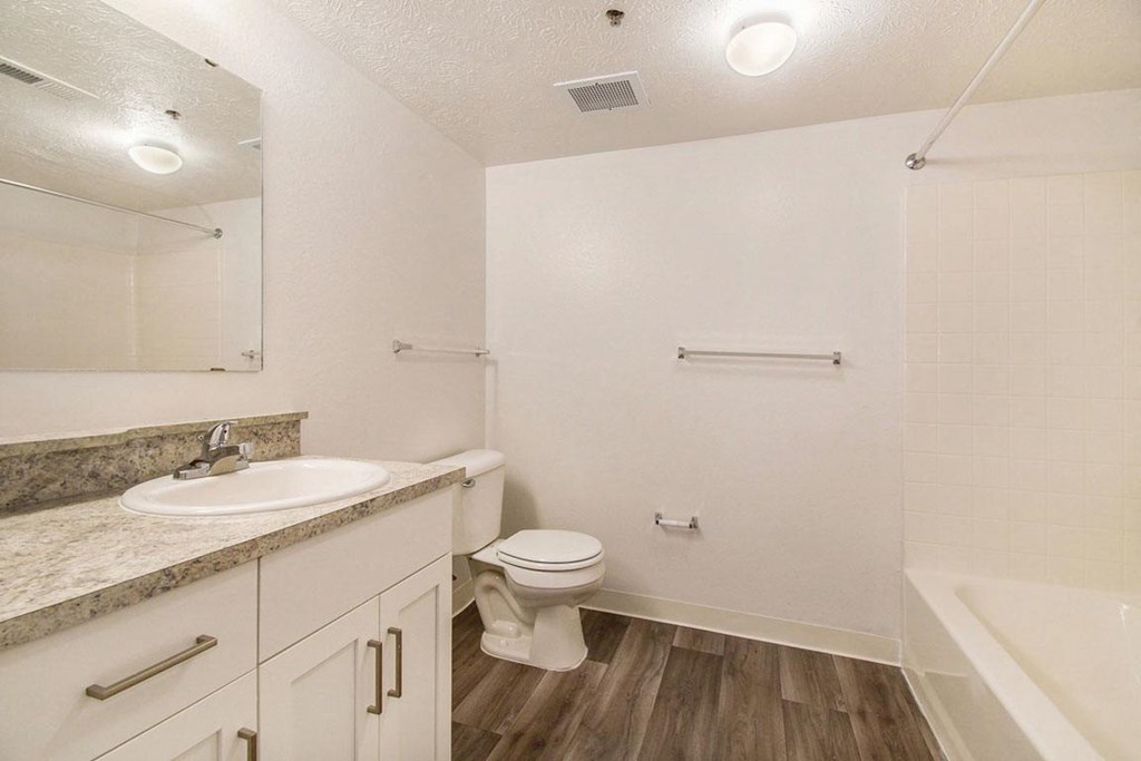 a renovated bathroom with hard surface floors and white cabinetry at Canal 2 Apartments, Lansing, Michigan