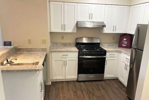 a renovated two bedroom two bath kitchen with white cabinets