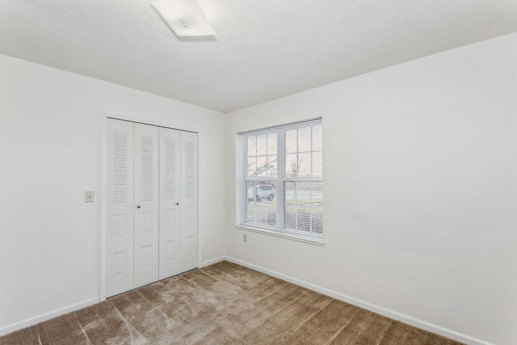 a bedroom with a window and a closet at Colonial Pointe at Fairview Apartments, Bellevue