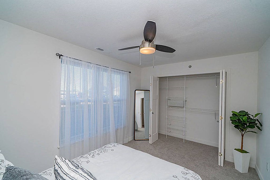 a bedroom with a large closet with wardrobe organizers