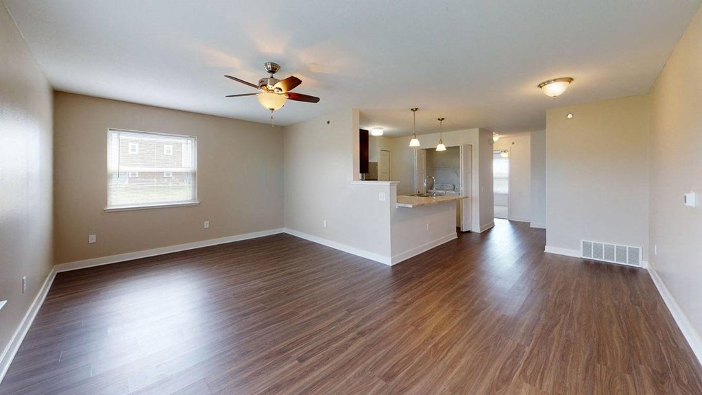 End living room with a ceiling fan and hard surface flooring at Copper Creek Apartment Homes in Maize, KS 67101