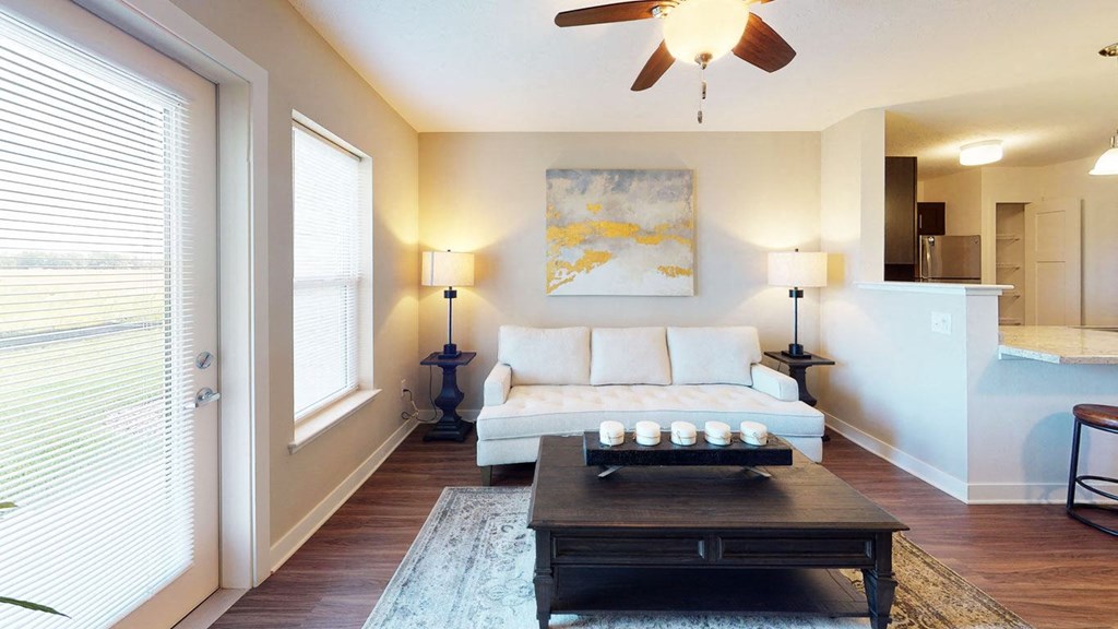 a living room with a large window and a door to private patio at Copper Creek Apartment Homes in Maize, 67101