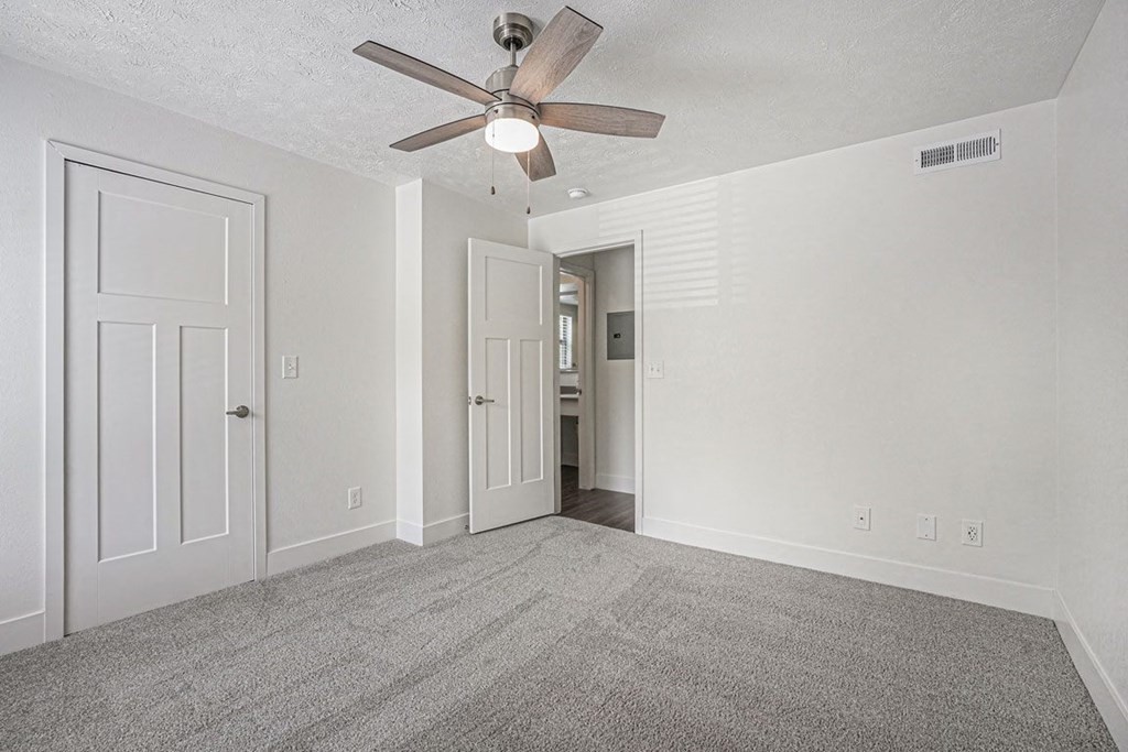 bedroom with a ceiling fan and walk in closet at The Crossings Apartments, Michigan, 49508