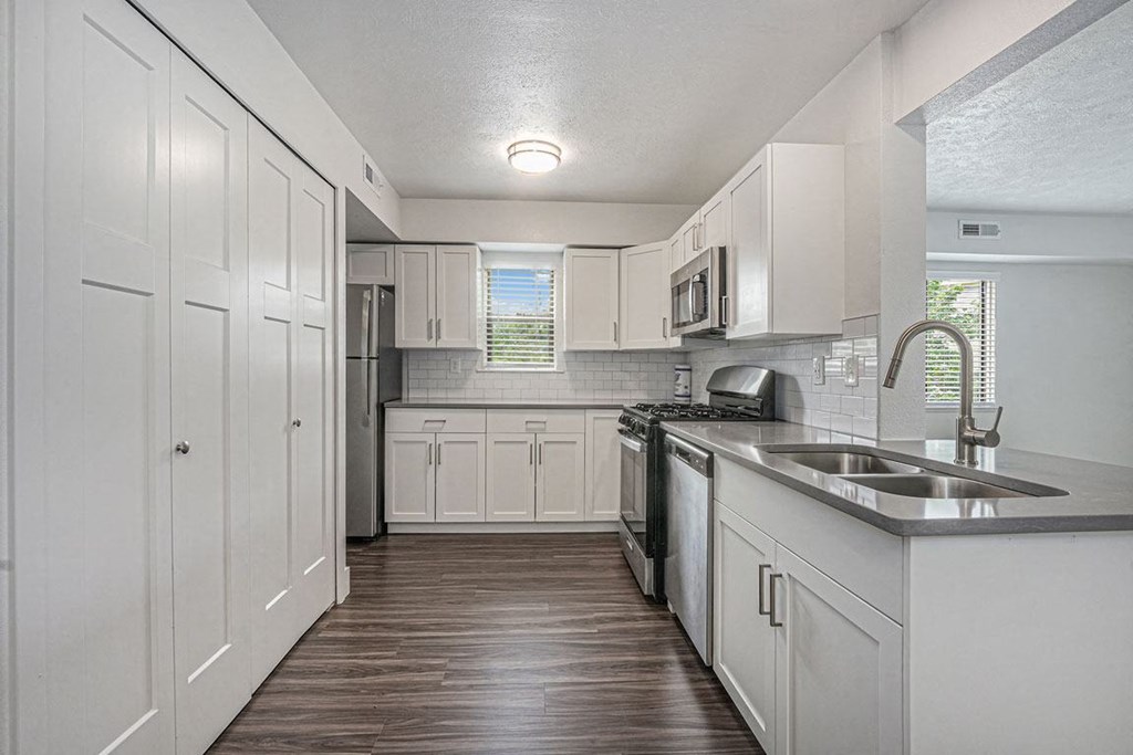 a kitchen with white cabinets and a window at The Crossings Apartments, Michigan, 49508