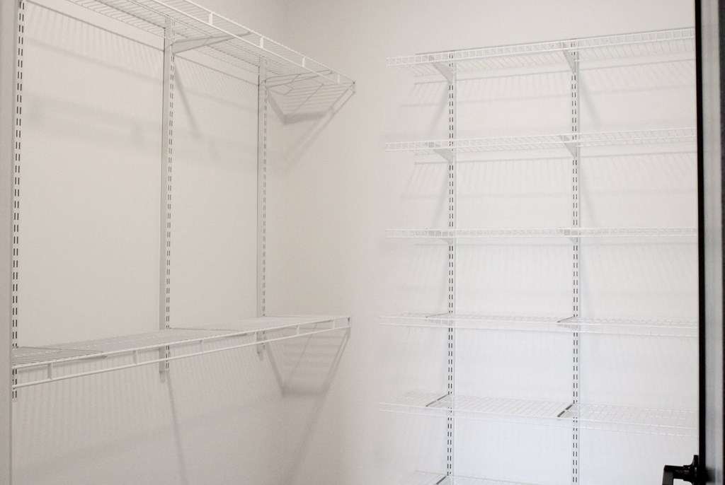 a walk in closet with white shelving and white walls  at Avant & Avant II, Carmel, 46032